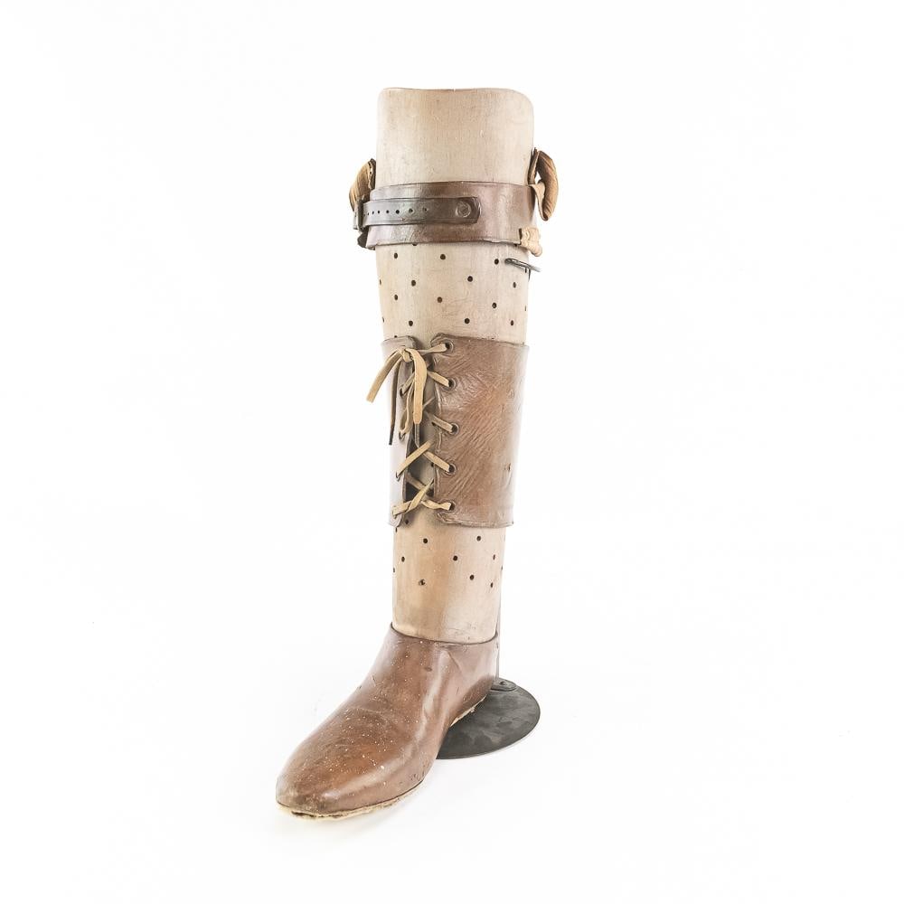 Antique Leather & Wood Prosthetic Leg W/Stand: This fascinating piece of medical history is an early-to-mid 20th-century prosthetic lower leg and foot, beautifully crafted from molded fiberboard, carved wood, and rich brown leather accents. It