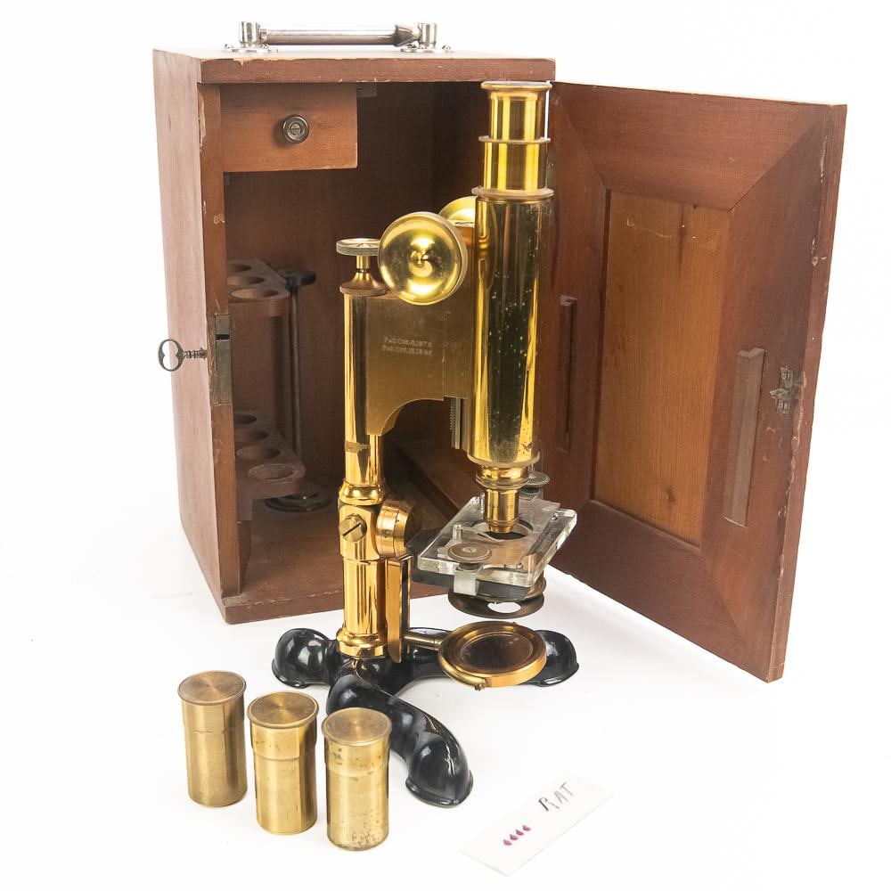 Antique Bausch & Lomb Brass Microscope: Late 19th-century monocular instrument manufactured by Bausch & Lomb Optical Co. of Rochester, New York, featuring a polished brass body tube, adjustment knobs, and stage mounted on a black-lacquered