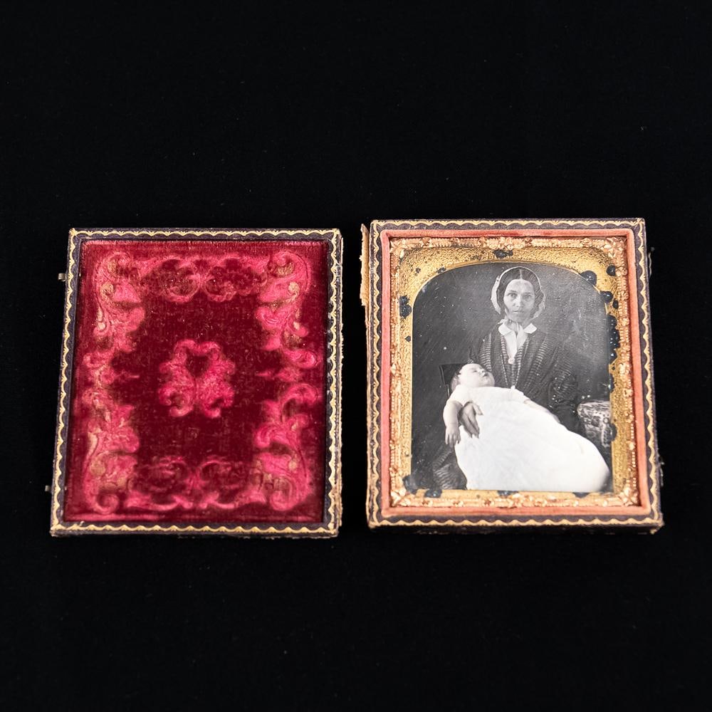 Mother Child Post Mortem Daguerreotype: Cased 1/6 plate Dag of a mother with deceased infant on her lap. In good condition. Resealed with archival tape. Case has a detached hinge. See photos. From the Allen Koenigsberg collection.