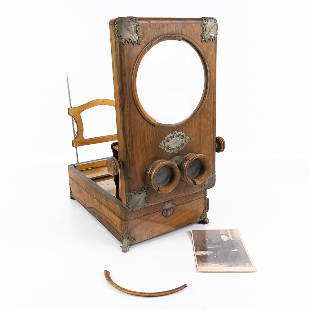 Victorian Folding Table Stereoscope & Card: This Victorian-era folding table stereoscope features a rich wood cabinet construction accented with decorative nickel-finish metal corner brackets, ornate escutcheons, and matching side adjustment