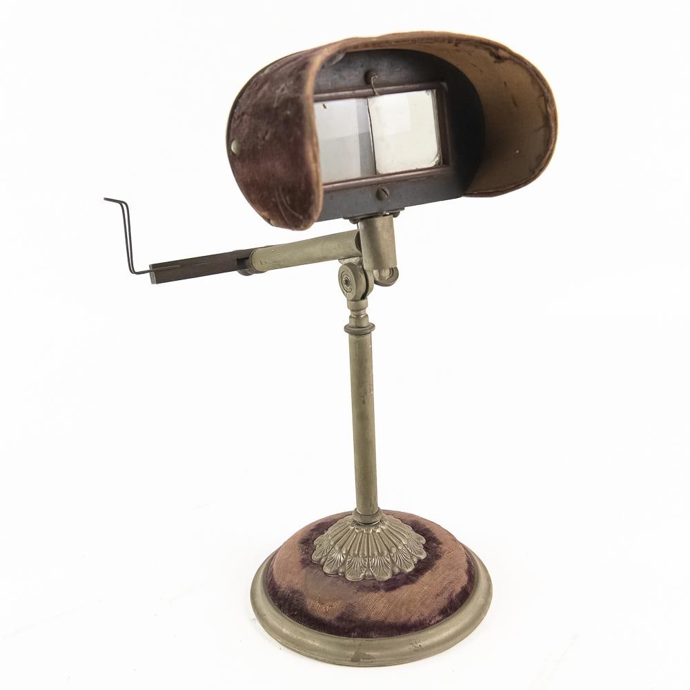 Victorian Parlor Stereoscope Viewer: Step into the Victorian parlor with this charming antique tabletop stereoscope viewer. Featuring a handsome nickel-finish brass stand mounted on a velvet-covered weighted circular base, this optical