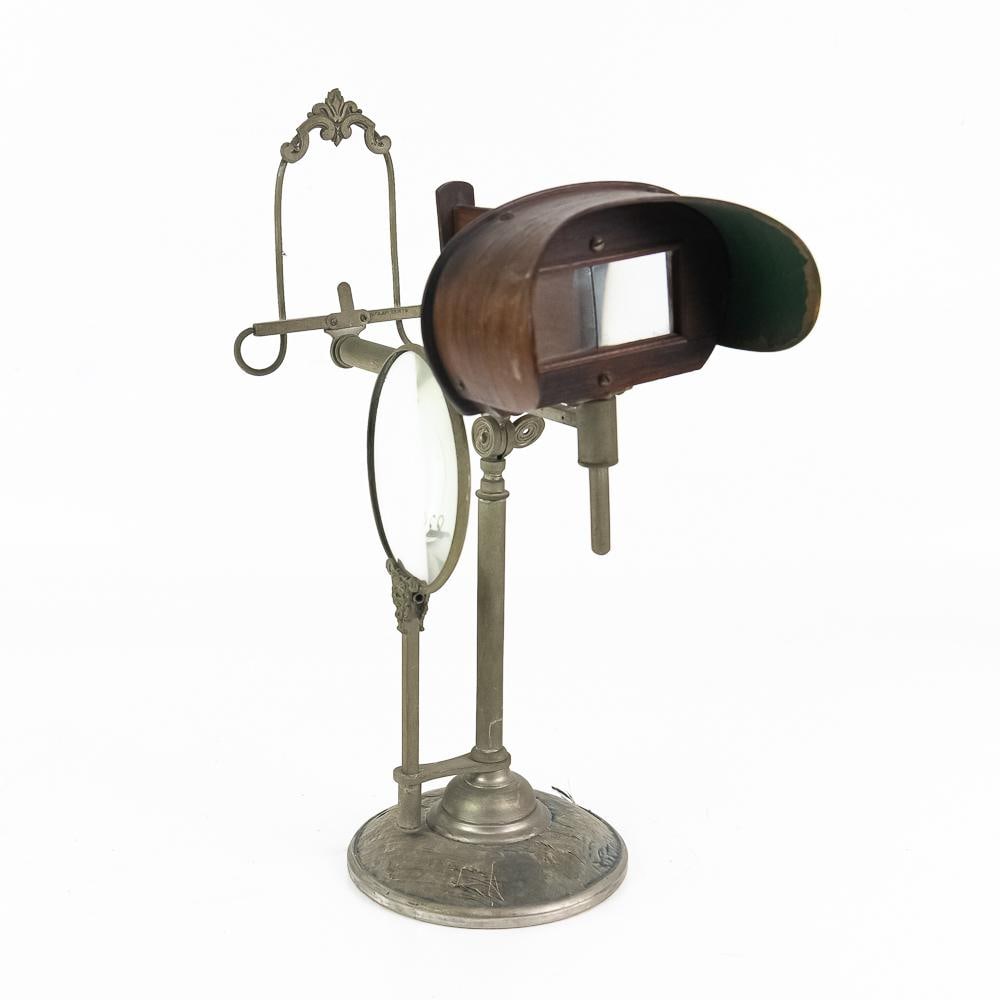 Victorian Tabletop Optical Magnifier Stand: This fascinating antique optical reading and display stand exhibits exceptional Victorian craftsmanship, featuring a cast metal with a central vertical post holding a circular secondary filter lens, a