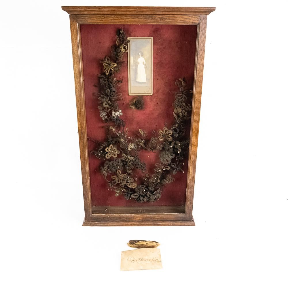 Victorian Hair Wreath Shadow Box Memento: This striking piece is a premier example of 19th-century Victorian mourning and sentimental art, featuring an intricately woven human hair wreath mounted on a vibrant red velvet background within a