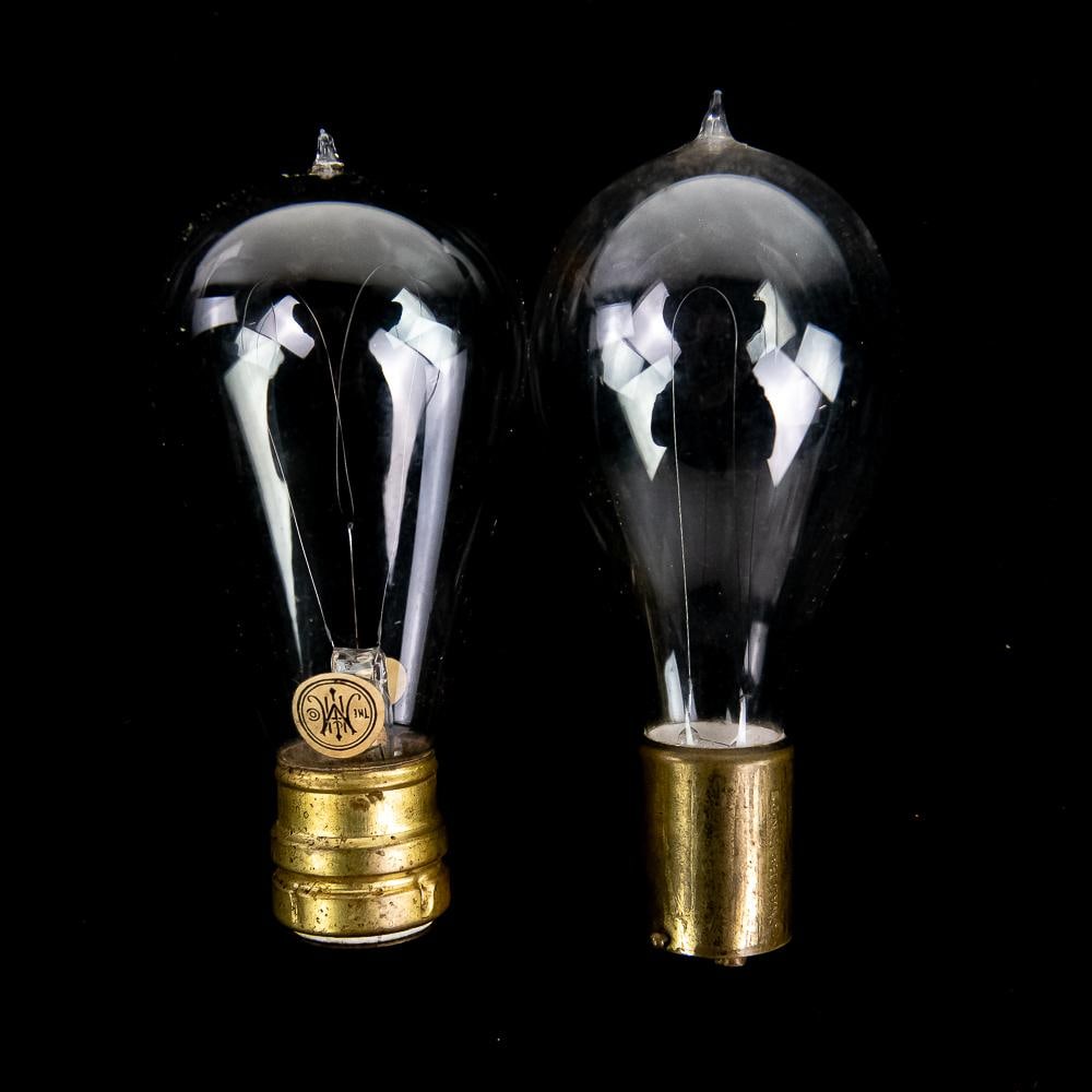 Early Antique Light Bulbs Thomson-Houston: A rare pair of early antique incandescent light bulbs reflecting late 19th- to early 20th-century electrical development. One bulb features a Thomson-Houston base measuring approximately 5" in length
