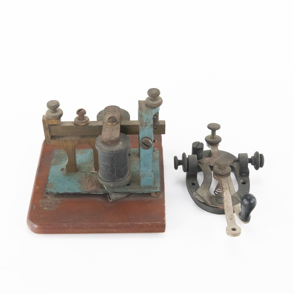 MESCO Telegraph Sounder & Key: An early 20th-century telegraphy set featuring a brass sounder manufactured by the Manhattan Electrical Supply Company (MESCO) mounted on a finished wooden base, alongside an unmounted telegraph key