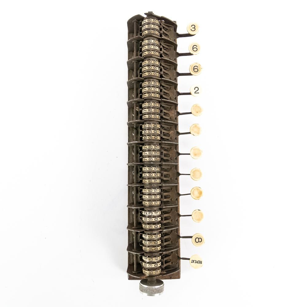 Analog Calculating Mechanism: Early mechanical calculating mechanism or tally register module, featuring exposed gear-driven brass and steel counter wheels, an end-mounted knurled adjustment knob, and a bank of cream-colored