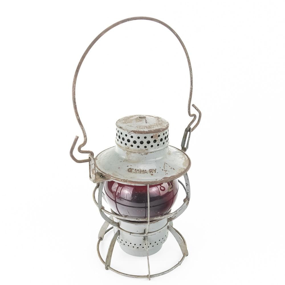 Vintage Dressel Omaha Ry Lantern: This vintage Dressel railroad lantern, embossed "OMAHA RY." on the brim and "DRESSEL ARLINGTON N.J." on the top cap, features a painted metal cage frame housing a deep red glass globe. Manufactured
