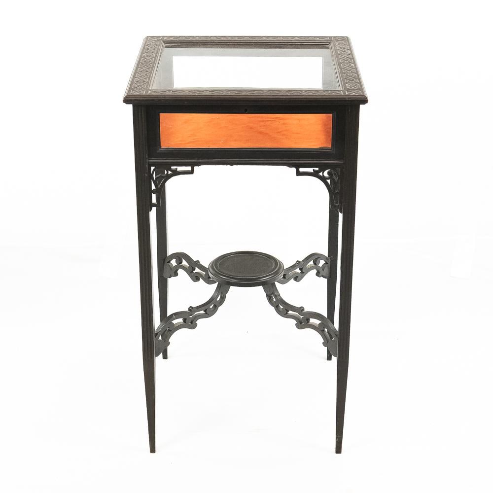 Antique Wood Glass Vitrine Display Table: This striking Edwardian-style vitrine display table features a beautifully carved geometric top border framing a hinged glass lid, designed to elegantly showcase collectibles over its vibrant,