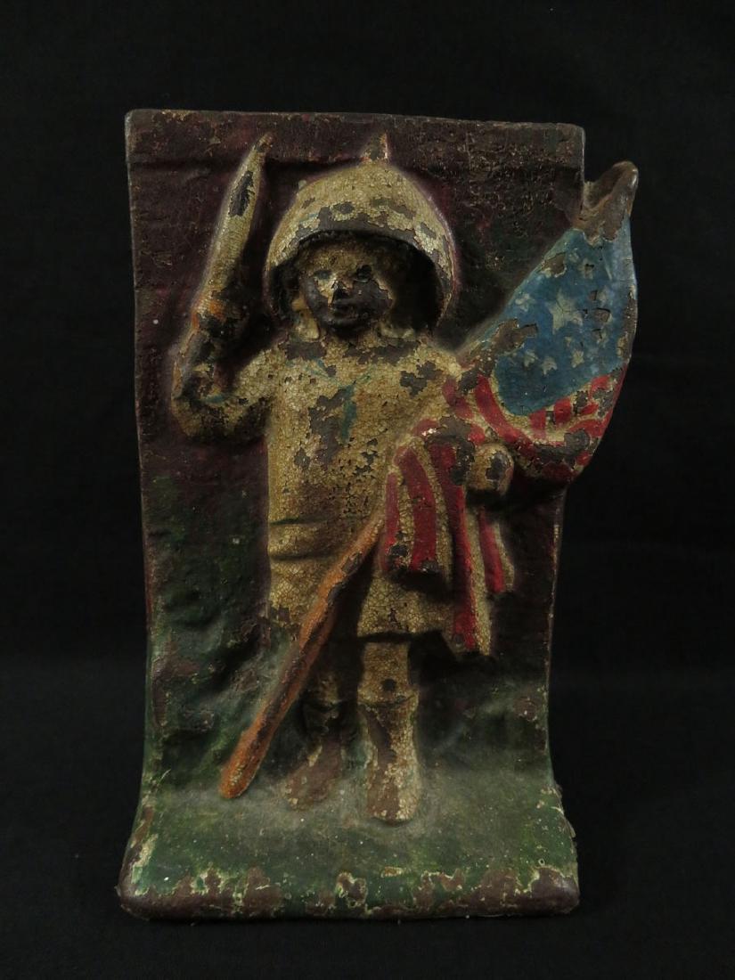 Doorstop Cast Iron Patriotic Soldier Boy: TYPE:Antiques SUB TYPE:Doorstop REGION:United States SUB REGION: MEDIUM:Cast Iron SGD/UNS:Stamped Reverse TITLE:Doorstop Cast Iron Patriotic Soldier Boy CATALOG NOTES:Very rare and early cast iron doo