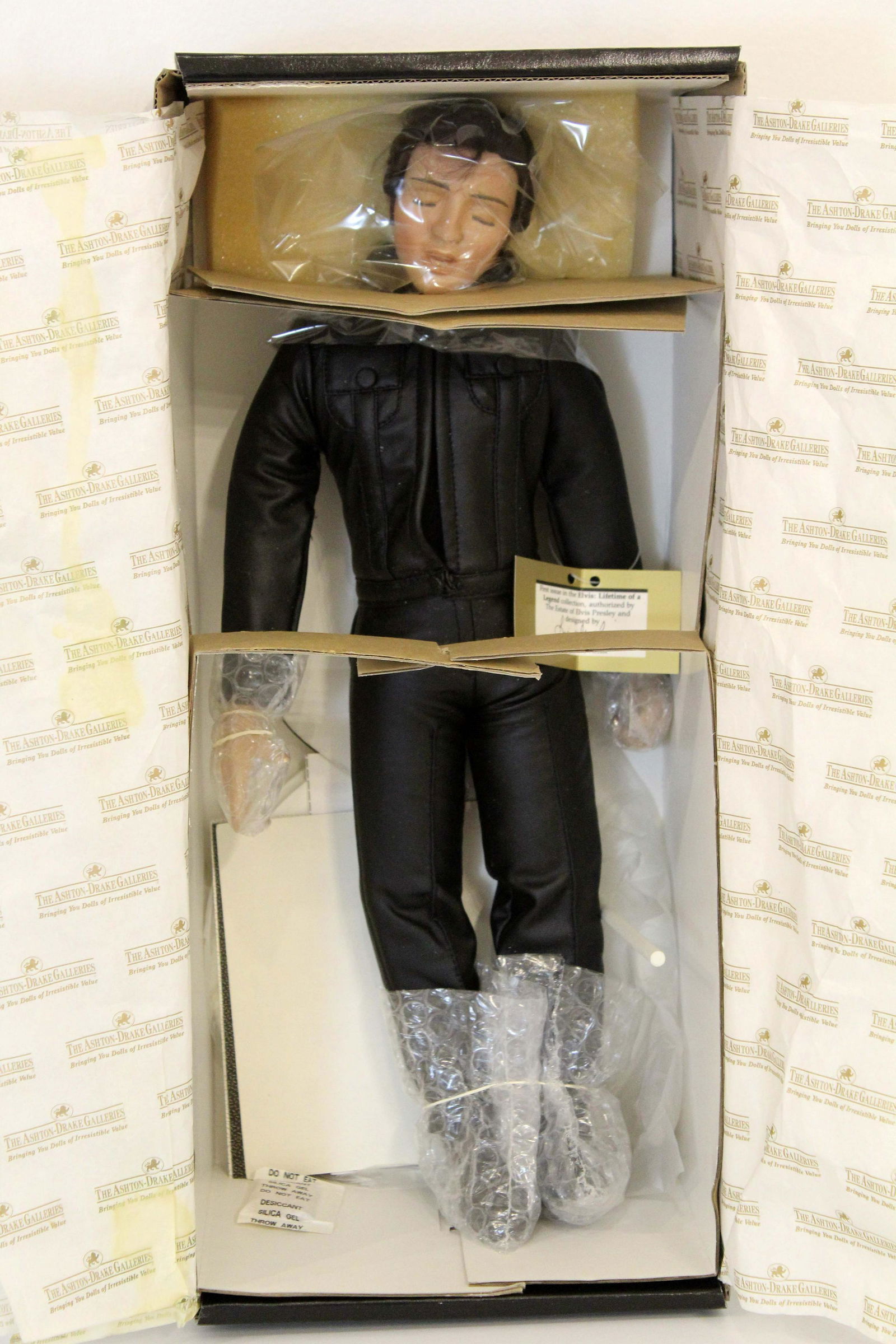 Elvis Lifetime of a Legend 1968 Doll in Box Designed by Lia Di Leo Ashton Drake: A unique collector's item for fans of the King of Rock and Roll - a porcelain Elvis doll, dressed in black leather with a metal microphone. This was a re-release from Ashton Drake galleries in 1991. D