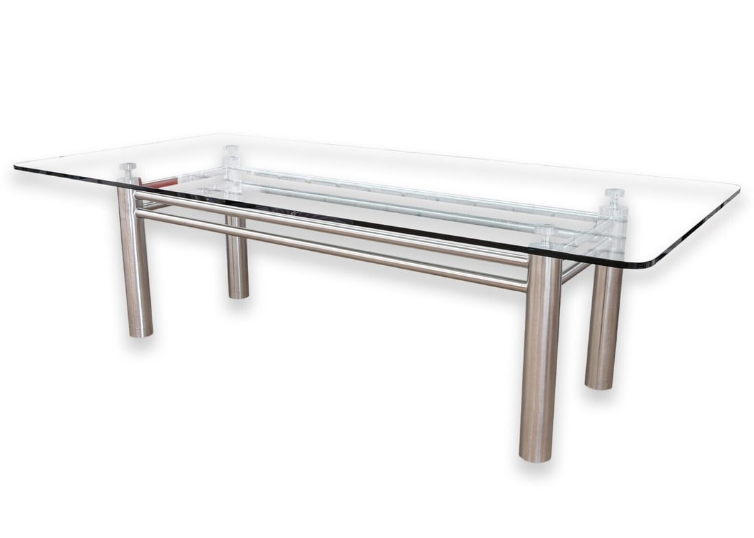 Brueton Contemporary Modern Stainless Steel and Glass Dining Room Table w Wheels: A contemporary modern glass and chrome steel dining table. This wonderful dining table features a large, thick rounded glass tabletop. The tabletop sits on a beautiful modern chrome steel base with a