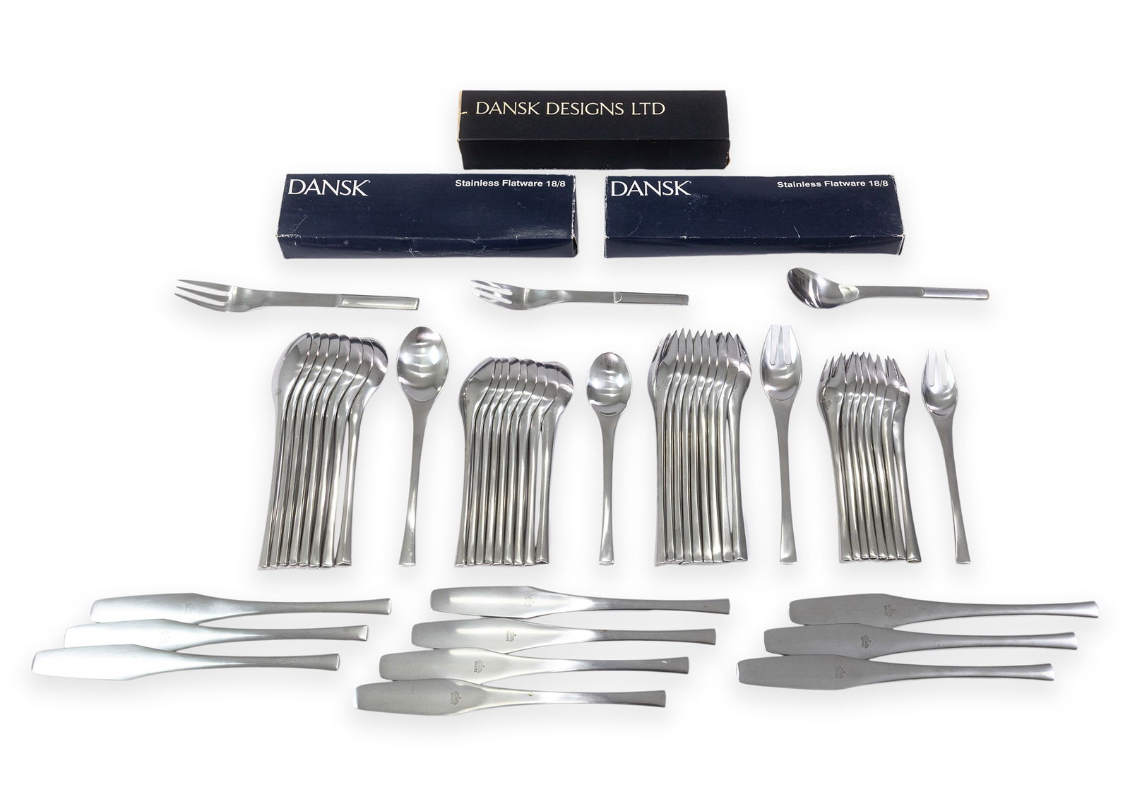 Dansk International Japan Flatware Stainless Silver + Box of Orange Tapered Dinner Candles: Group of Dansk International flatware together with a box of orange tapered dinner candles. The flatware is marked “Dansk International Japan”, and includes assorted dinner knives, forks,