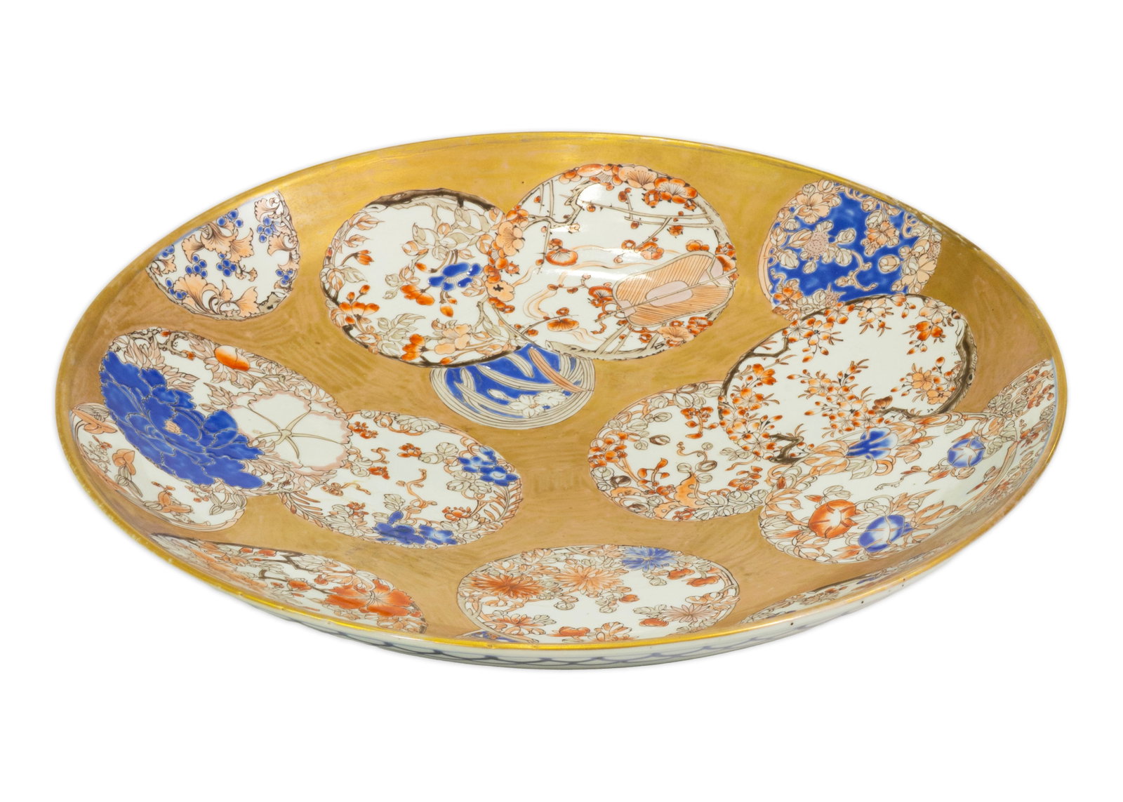 Japanese Imari Style Porcelain Charger with Gilt Ground and Floral Reserves 1850: Large Japanese Imari-style porcelain charger featuring an elaborate gilt ground decorated with overlapping floral and botanical reserves in vivid iron red, cobalt blue, and white enamels. The composit