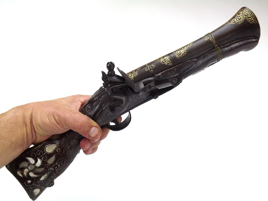 18-19th C. Fine Gold inlaid Islamic Ottoman Turkish: A beautiful large example of Bladerbasss hand pistol of an Ottoman origin. With a massive steel barrel of very heavy gauge. Heavily inlaid with gold koftgari work. With its extensively carved wooden s