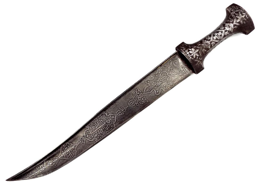 18th-19th C. Islamic Turkish Persian Wootz Damascuc: With its large single-edged blade of T-section form, showing fine Damascus patters and silver-inlaid Islamic calligraphy to both sides. Steel hilt with carved floral decorations. Total Length - 18" Le