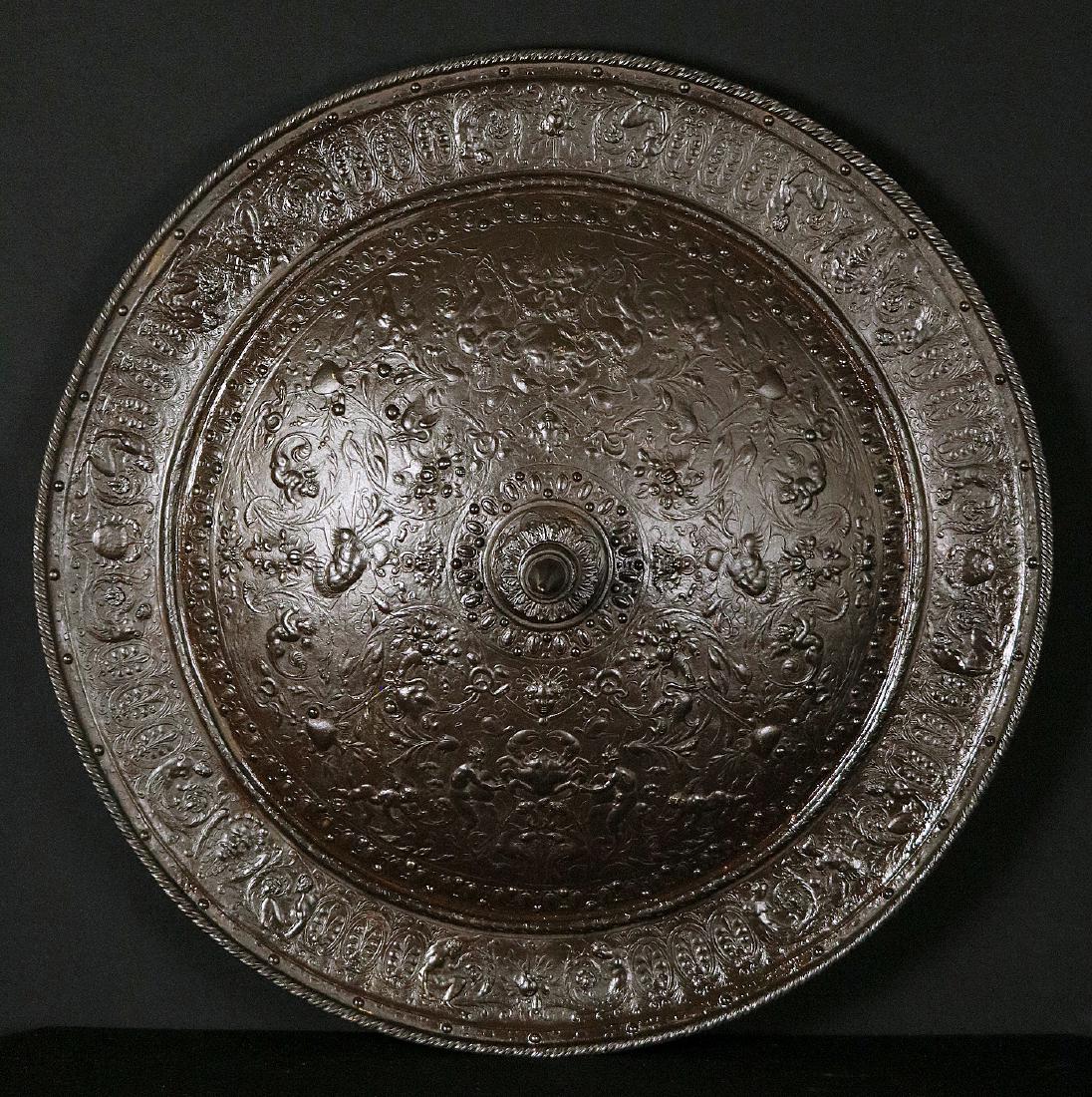 Very Large 19th C. Cast Iron Shield in the style of: Very Large 19th C. Cast Iron Shield in the style of Medieval Parade Armor. Massive example of the Victorian era representation of the Medieval or early Renaissance era Parade Armor normally owned by r