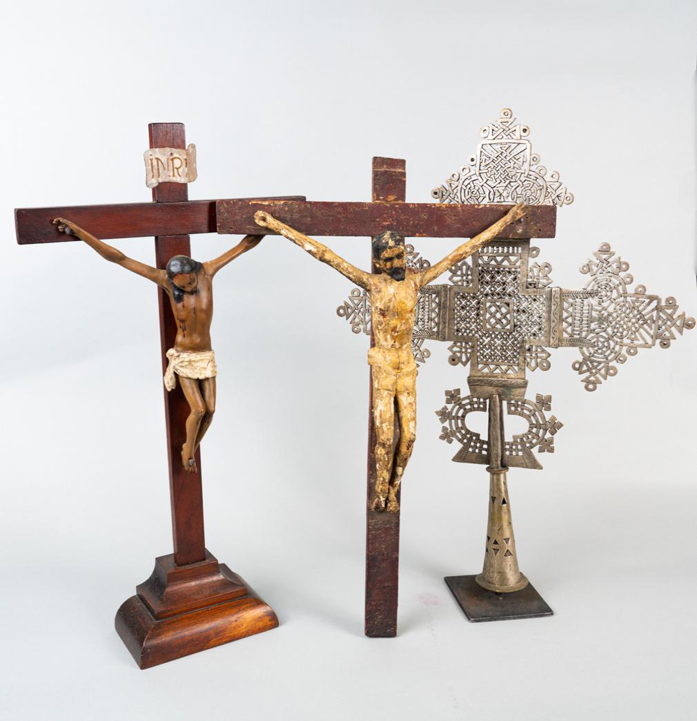 Lot of Three Christian figurines: First - Rare 18th Century Colonial gesso wood carved crucifix with glass eyes. Handmade nails. Later restoration. Its dimensions are 26" high x 28" width. Second - Gothic style antique crucifix featur