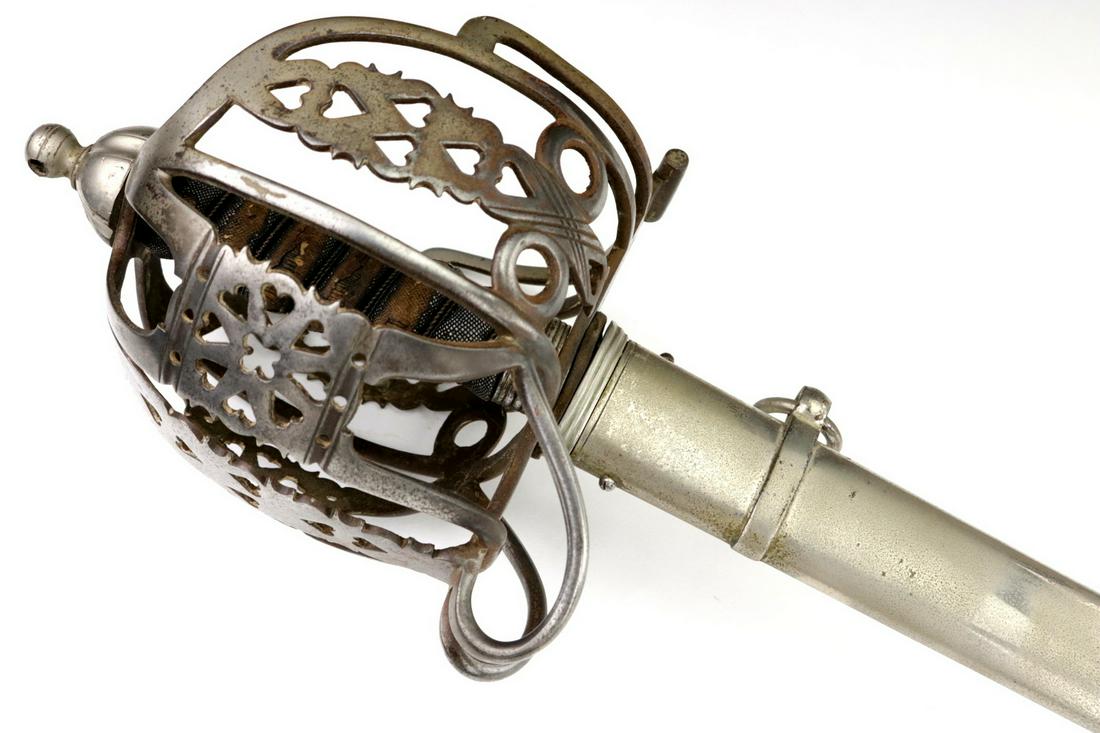 A 19th C. English Scottish Officer's Basket Hilt Broad: Nice large example with its pierced steel basket guard and shark skin covered grip. Mounted with a powerful double edged and double fullered blade featuring fine quality deeply etched decorations, inc