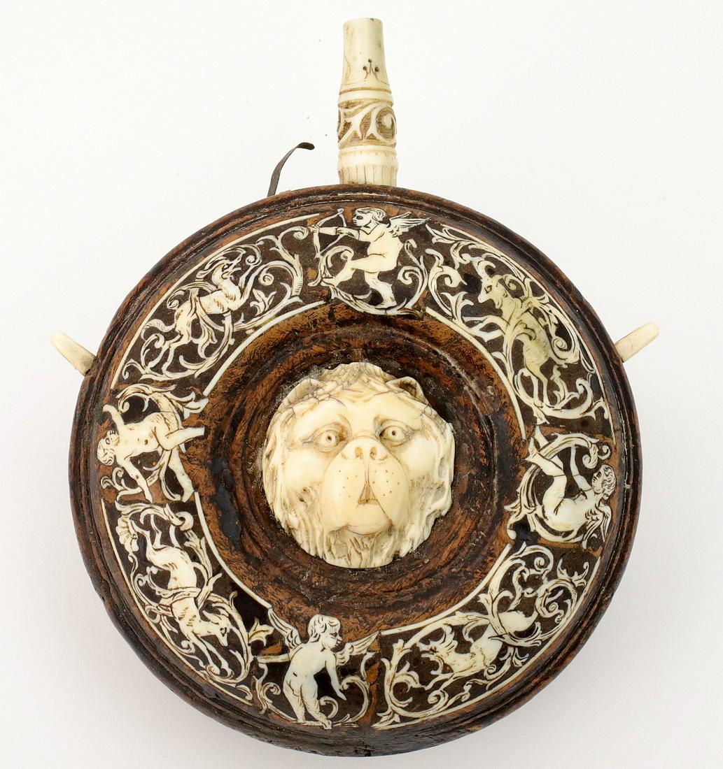 Fine Carved & Inlaid 16th-17th C. Powder Flask: Fine Carved & Inlaid 16th-17th C. Powder Flask. With its wood body profusely inlaid on both sides with cherubs and scrolls, having relief carved dog-faces to the center on each side. Beautiful and ear