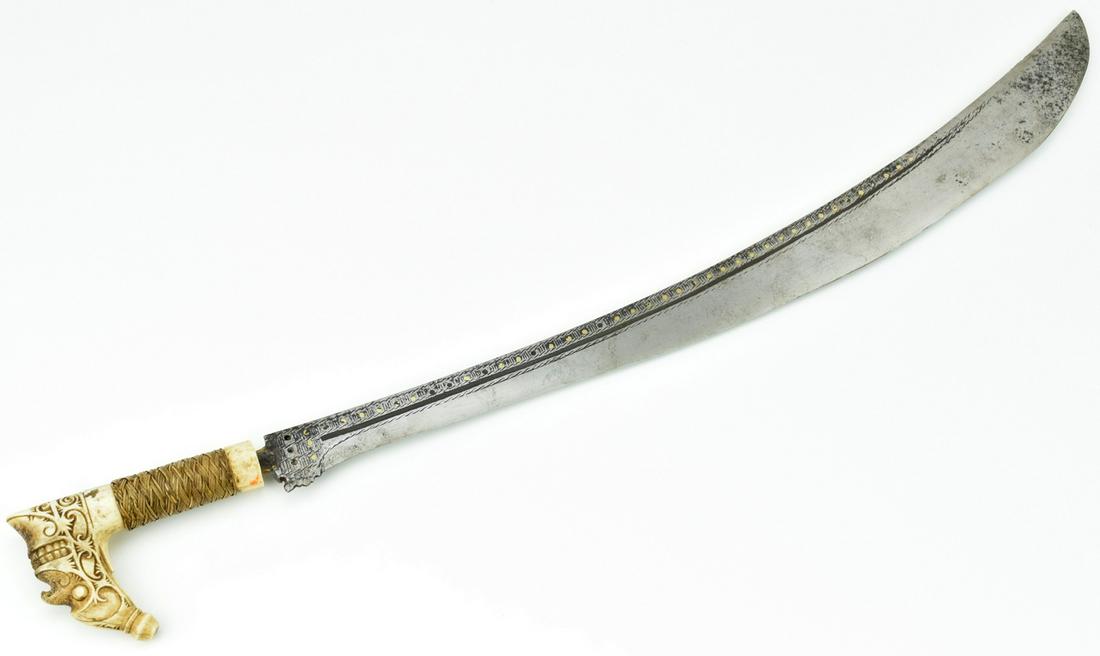Very Good 19th C. Indonesian Head Hunter's Sword of: A truly fine and rare Tribal weapon used by the Head Hunters of Dayak warriors from the Borneo islands. Featuring a spectacular carved bone grip showing a wonderful carved details with a grotesque fac