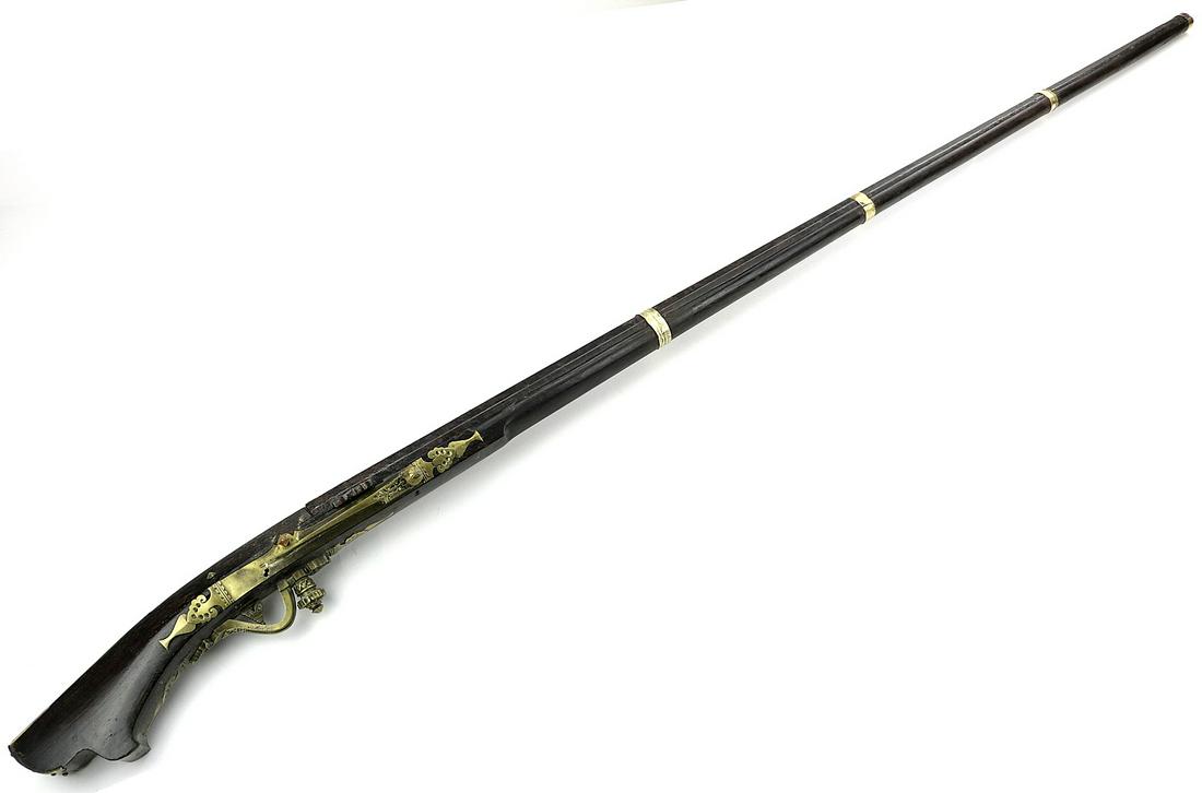 Rare 19th C. Indonesian or Malaysian Match-Lock Long: Rare 19th C. Indonesian or Malaysian Match-Lock Long Rifle Gun. With its heavy solid brass mounts and strong wood stock, match-lock lever lacking, otherwise a good looking and rare example used by Asi
