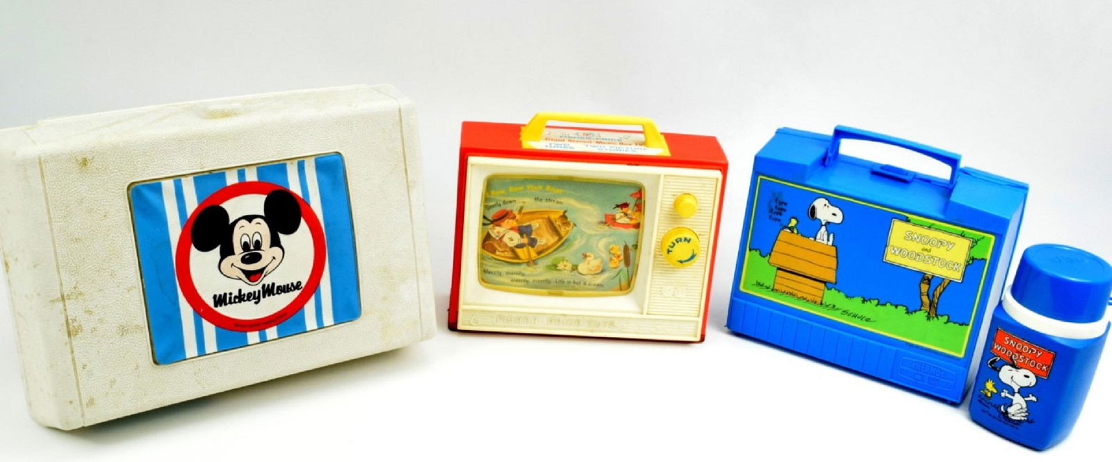 Lot 2 Vintage Toys And Snoopy Lunch Box: Great lot with Snoopy and Woodstock lunch box with thermos, General Electric Mickey Mouse record player and Fisher Price two tunes TV. Great addition to any toy collection. 13 7/8" x 5 1/2", 9 7/8" x