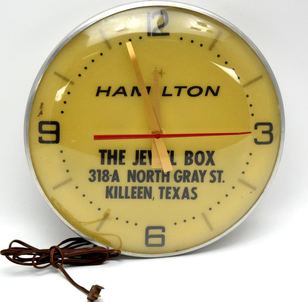 VINTAGE c.1950's HAMILTON WATCHES THE JEWEL BOX LIGHTED CLOCK: Nice original advertising lighted clock c.1950's. Hamilton line of wristwatches and pocket watches. Glass dome . Advertising is from " The Jewel box" retailer in Texas. Very good original condition. D