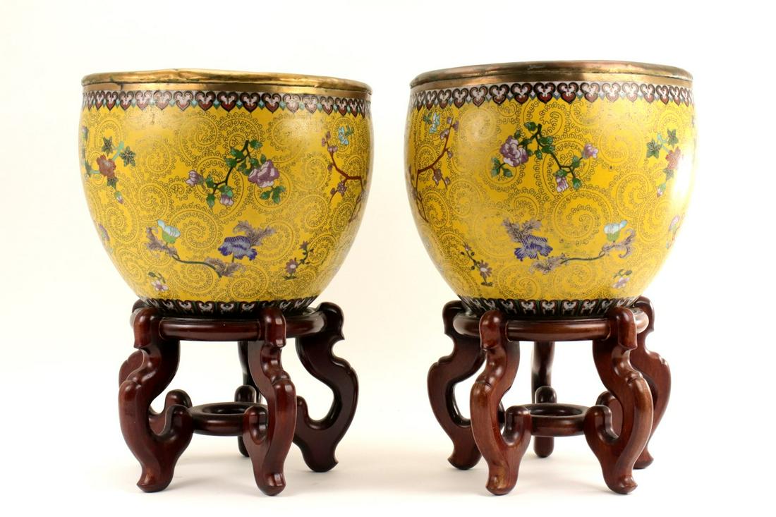PAIR ANTIQUE CHINESE CLOISONNE ENAMEL FISH BOWLS PLANTERS: Very fine pair antique Chinese cloisonne enamel fish bowls/planters depicting peach blossoms raised on wood stands. Bright colors, great original condition. Inside shows some age wear. Beautiful examp