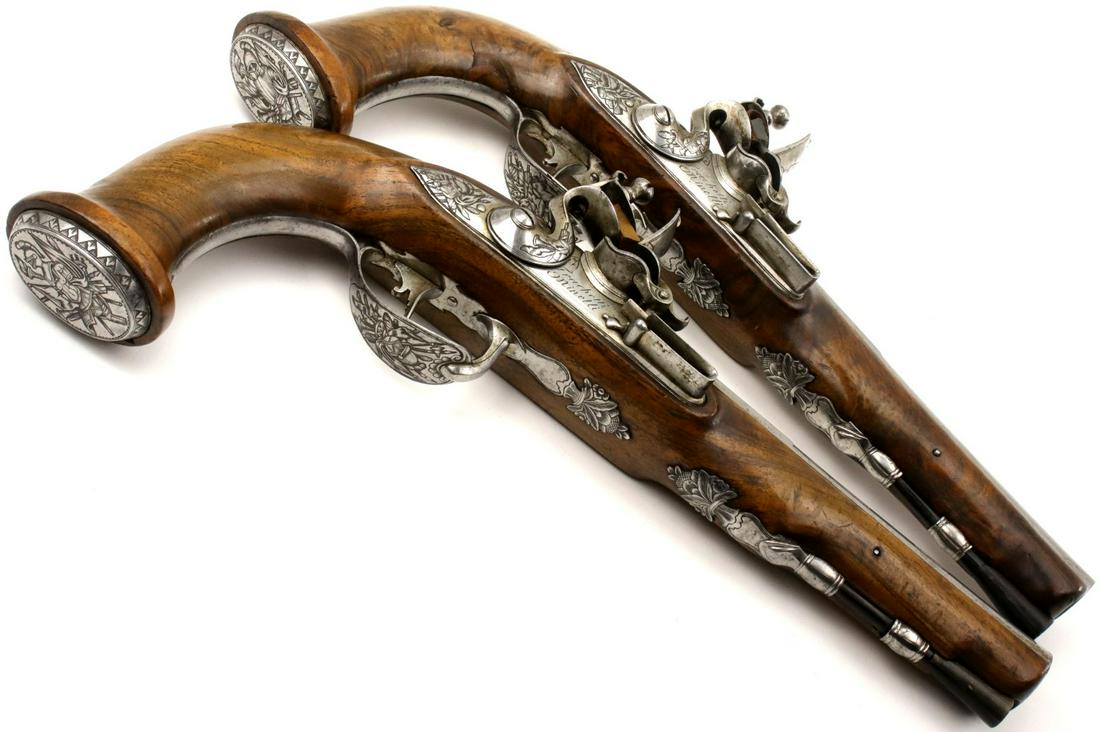 Deluxe Pair of French Napoleonic Officer's Pistols, Exquisite Chiseled Steel Mounts & Locks with War: Deluxe Pair of French Napoleonic Officer's Pistols, Exquisite Chiseled Steel Mounts & Locks with War Trophies and Arms & Armor Panoplies, Exclusive to Each Pistol. Locks Engraved with a Maker. Total l