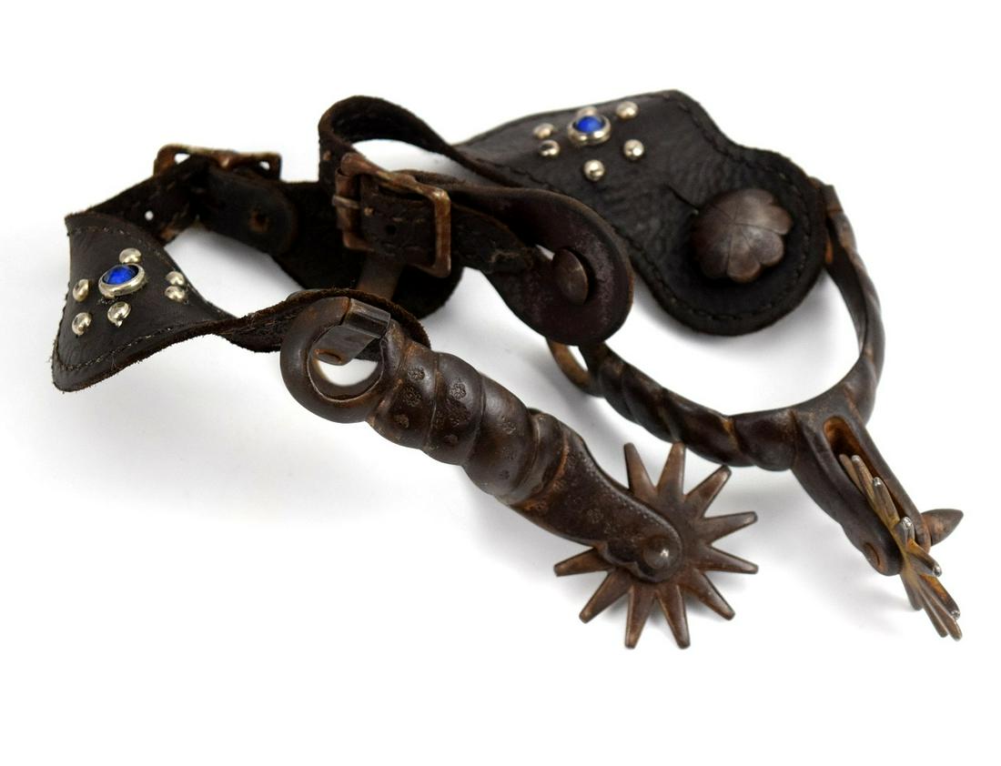 Pair Antique August Buermann Hand Wrought Decorated Iron Western Spurs: Pair fine antique August Buermann hand wrought decorated iron Western spurs with fancy decorated leather straps. Faint star marked on the top of shank and the word "Patent" on the bottom. Rare find pa