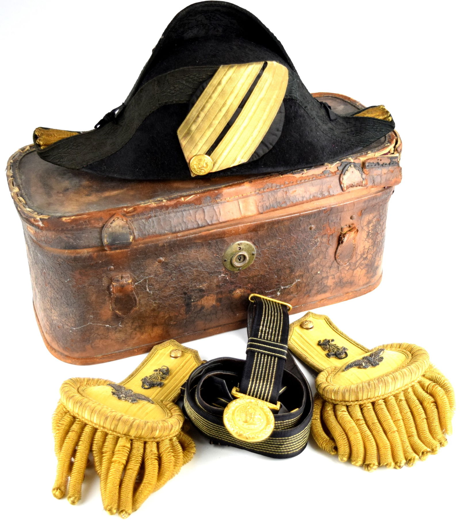 A cased set of chapeau and epaulettes for a Navy US Captain: A cased set of chapeau and epaulettes for a Navy US Captain in leather case. Case Size: 17" x 7" x 7". ~ . Detailed condition reports are not included in this catalog. For additional