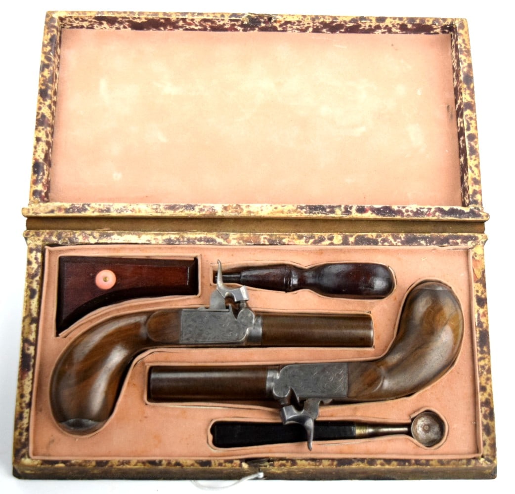 Attractively Cased Pair Of Continental European Percussion Pocket Pistols With Engraved Locks: Attractively Cased Pair Of Continental European Percussion Pocket Pistols With Engraved Locks, Turn-Off Barrels and Drop Triggers, Circa 1850, With Accessories. Case size: 11" x 5 1/2" ~ . Detailed co