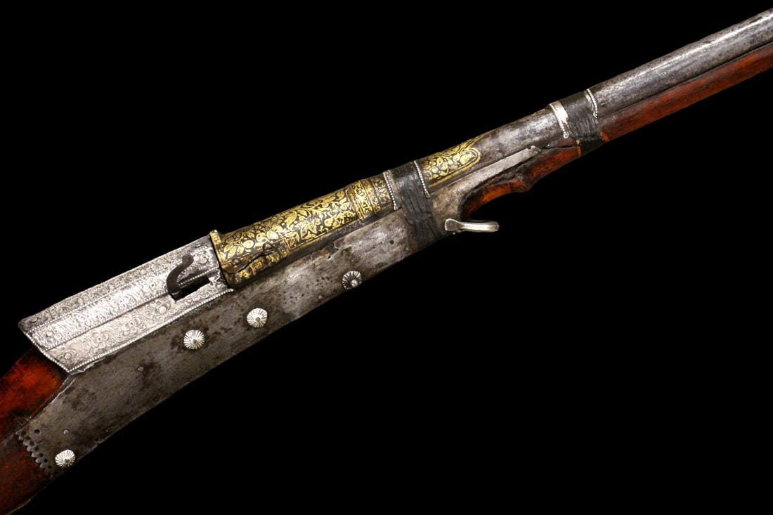 Very Fine Late 18th C. Indian matchlock long riffle with gild decorated barrel: Striking long gun of Indian tradition, featuring an exceptionally long barrel and richly decorated furniture. The lock area is fitted with a finely engraved, silvered (or bright steel) lock cover/plat