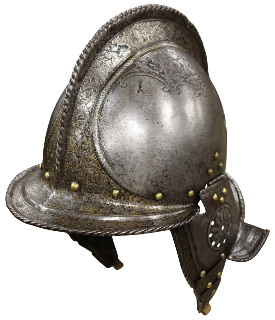 A SPLENDID ETCHED AND GILT MILANESE BURGONET CIRCA 1565: The helmet with one piece skull, decorated with bands of characteristic mid 16th century Milanese etching of foliage heightened with fire gilding. The medium height roped comb accentuates the elegance