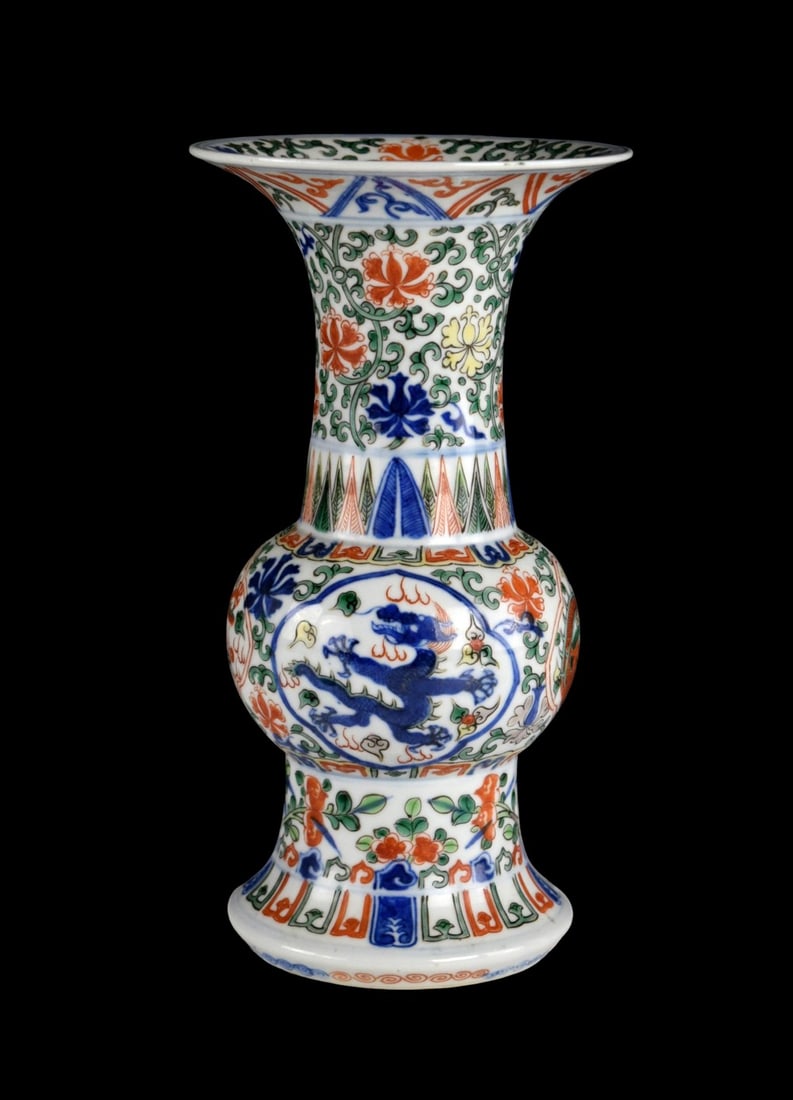 CHINESE PORCELAIN WUCAI ZUN-FORM DRAGON VASE: Rare wucai 'dragon' vase, gu. Wanli six-character mark and of the period. Modelled in the form of an archaistic gu vessel supported on a tall spreading foot with decorated leafy peach sprays and perch