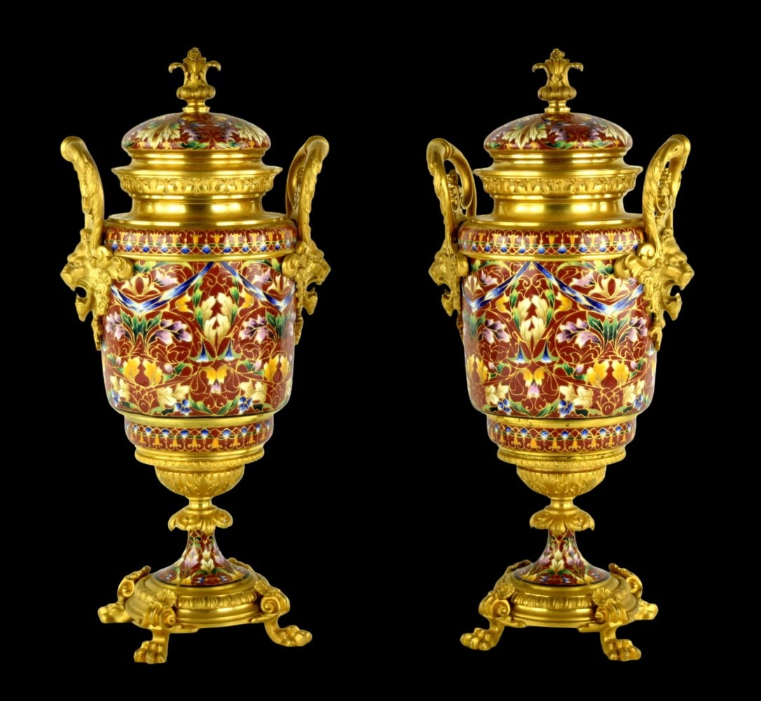 Pair Antique French Gilt Bronze Champleve Enamel Urns: A pair amazing French gilt-bronze and champleve multi color enamel lided urns, late 19th century, each with twin lion mask handles on matching bases raised on scrolled and molded feet. Size: 14 3/4" H