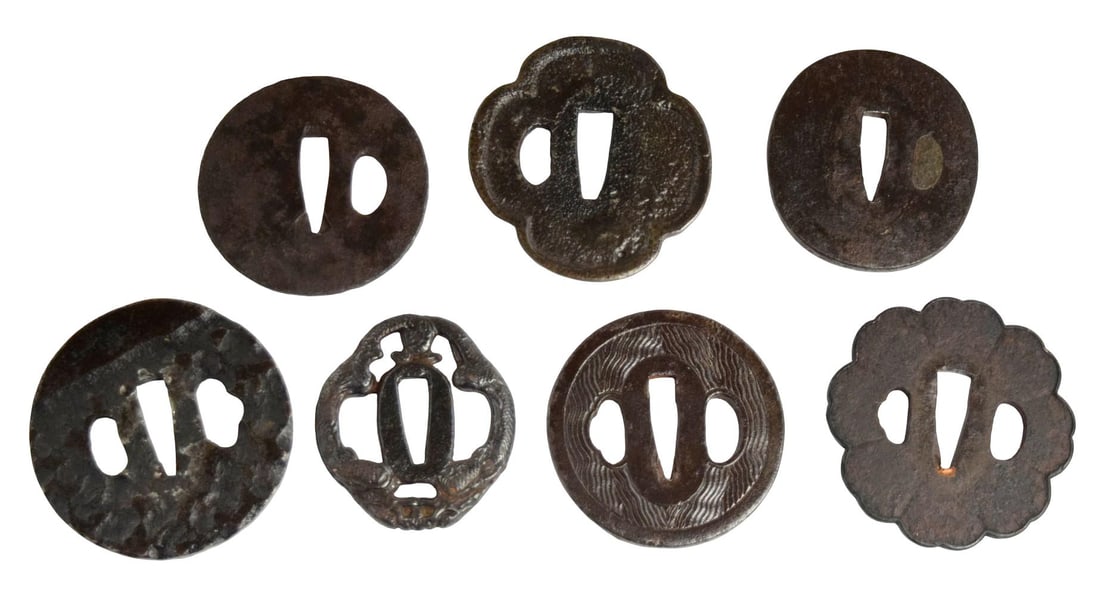 Collection of Seven Japanese Edo Period Iron Tsuba for Katana and Wakizashi: A collection of seven Japanese iron tsuba dating principally to the Edo period (1603–1868). The group includes both round (maru-gata) and mokko-gata examples with pierced nakago-ana and hitsu-ana, r