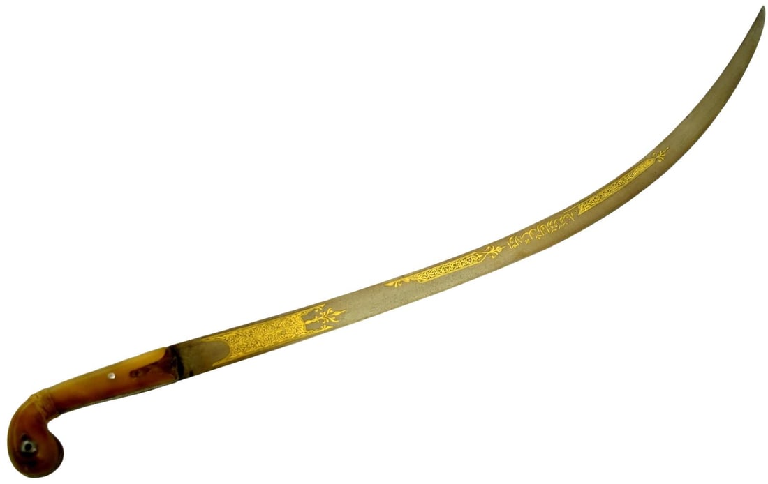 Very FIne 18th Century Indo-Persian Shamshir with Wootz Blade and Gold Koftgari: A fine 18th-century Indo-Persian shamshir with a deeply curved wootz steel blade, displaying a visible watered pattern throughout. The blade is richly embellished with gold koftgari decoration, includ