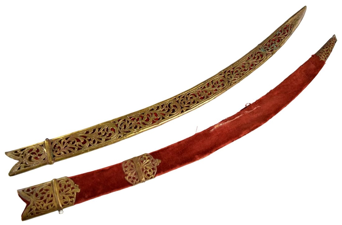 Lot of Two Indo-Persian Tulwar / Shamshir Scabbards, 19th Century: Lot of two antique Indo-Persian curved sword scabbards, suitable for tulwar or shamshir-type blades. The first is extensively fitted with pierced and chased gilt-brass mounts arranged over a red texti