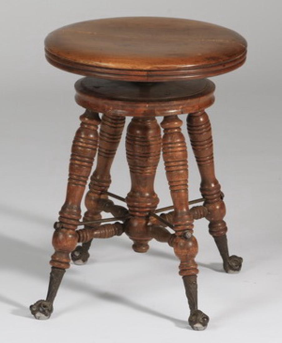 Victorian swivel top piano stool, 19"h: Victorian piano stool, late 19th or early 20th century, the circular swivel top surmounting a secondary top above four turned legs centering a column conjoined by an X-stretcher and terminating in bra