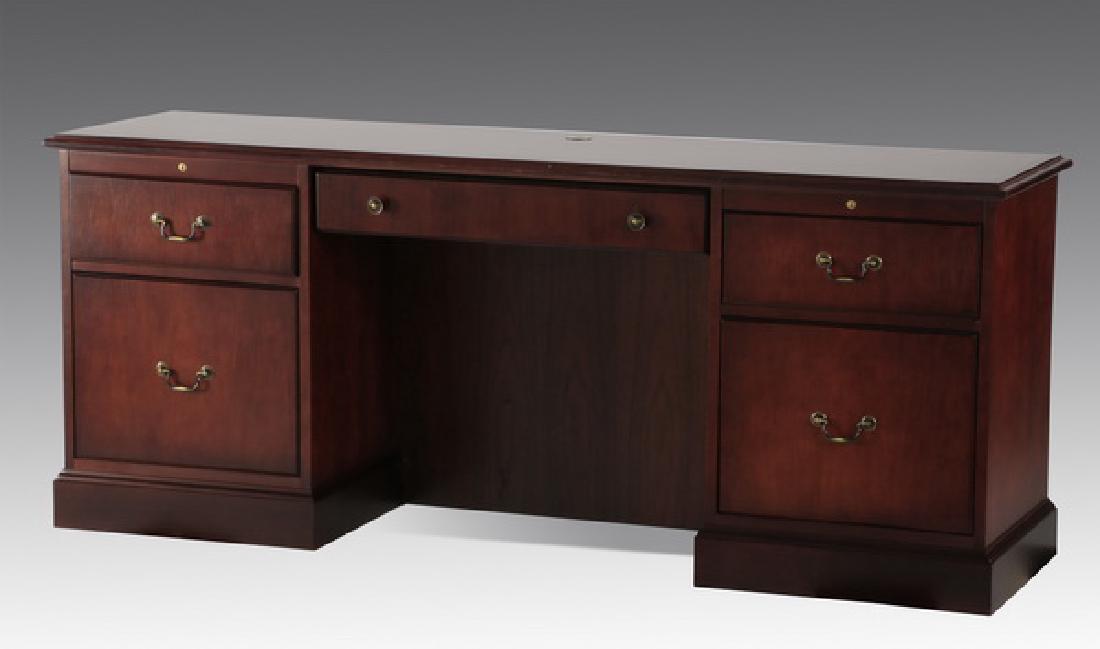 Steelcase executive mahogany credenza, 70"l: Contemporary mahogany credenza with three short drawers and two deep storage or file drawers, the top with a slot to accommodate voice, data and electrical cords, etc , 30"h x 70"l x 20"d.