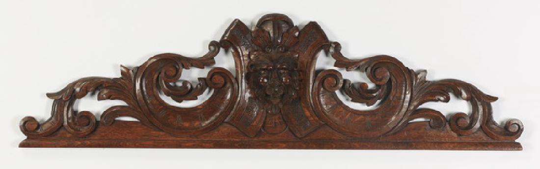 19th c. French carved overdoor with lion mask: French overdoor, 19th century, centering a carved figural mask of a lion flanked by acanthus scrolls, 14"h x 49"l x 5"w.