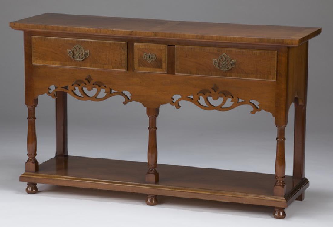 Baker Furniture console, 51"w: Baker Furniture console features a rectangular top with contrasting banding, surmounting a base having two drawers with brass batwing pulls over a carved and pierced apron, rising on turned legs with 