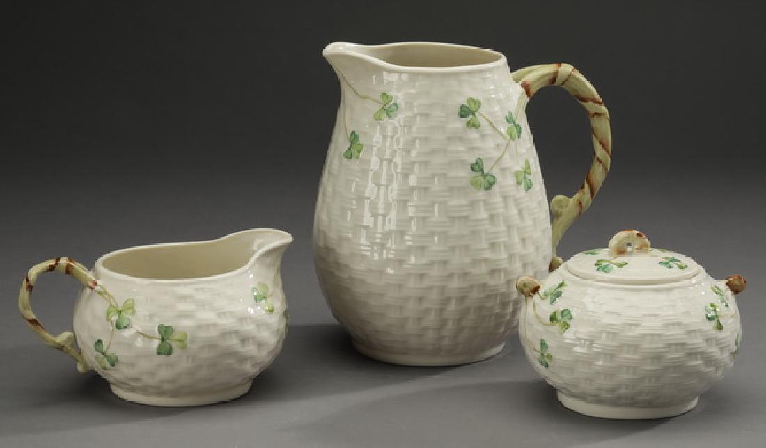 3 Pc Belleek porcelain 'Shamrock' table accessories: Belleek porcelain table accessories in the 'Shamrock' pattern, comprising: (1) pitcher, 6.5"h x 6"w; (1) cream jug, 3"h x 5"w; and (1) sugar bowl, 3"h x 4.5"d; each having a woven texture with hand pa