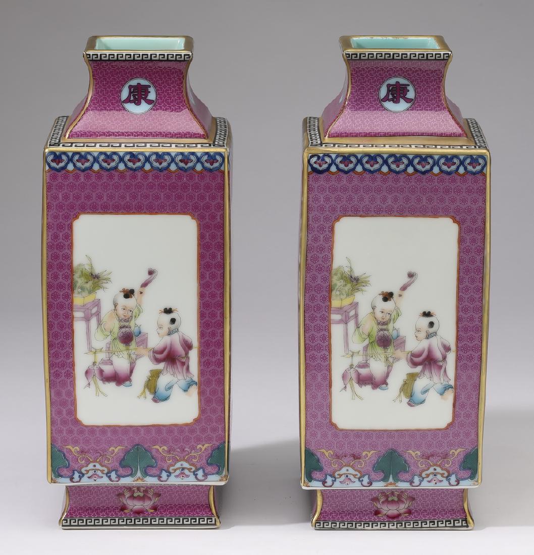 (2) Chinese famille rose cong vases, 10"h: Pair of Chinese famille rose cong vases, having square rims with gilt leiwen bands, above trumpet necks centering auspicious character rondels, leiwen, and ruyi bands, the bodies having two landscape 