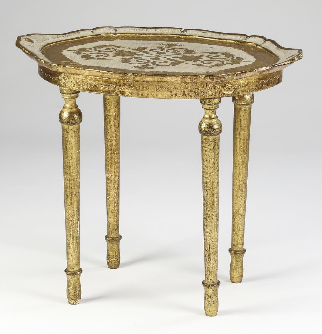 French style gilded petite occasional table: Petite occasional table in the French taste, the scalloped tray shaped top centering a gilded floral cartouche enclosed by a gilded band, above the incised apron with trailing foliate decoration, the 