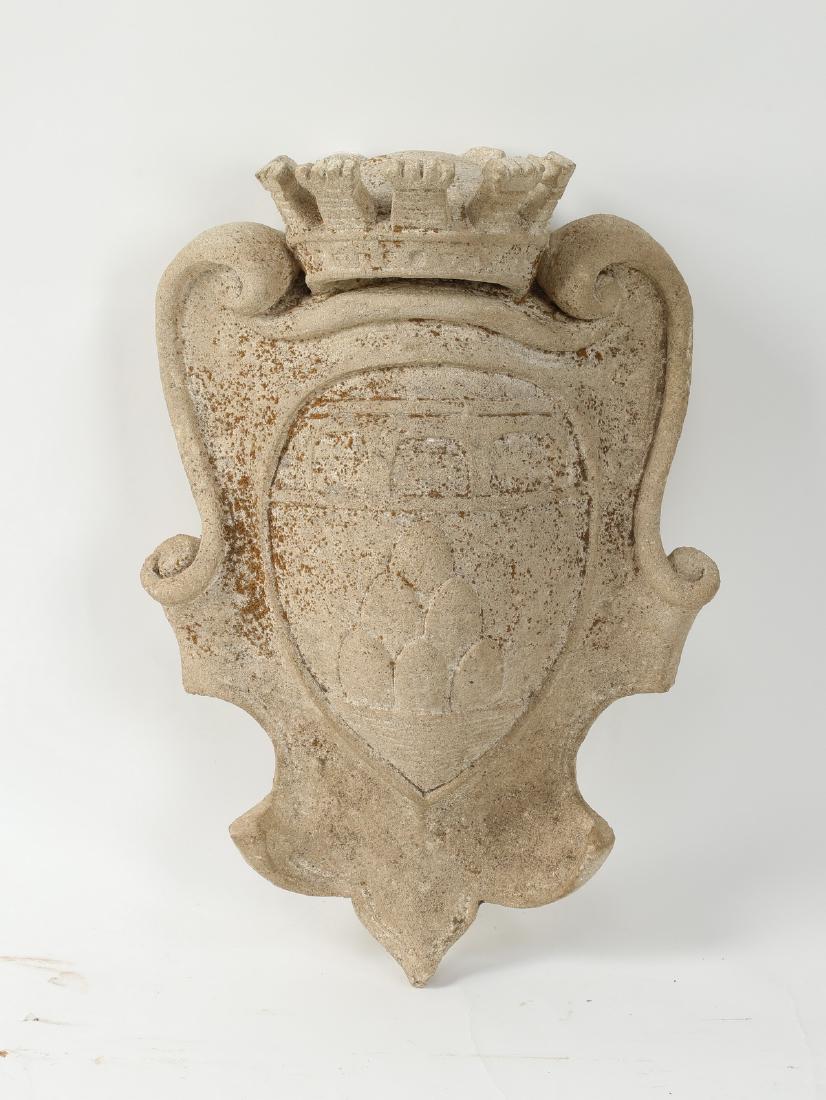 Continental heraldic crest in cast stone, 20"h: Cast stone Continental heraldic crest, having a crown above a central shield impressed with an heraldic emblem, and finished with a scrollwork shaped border, 20"h x 14"w x 7.5"d.