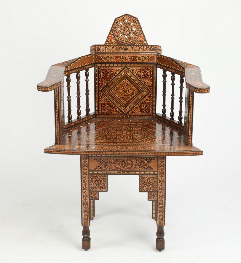 Moorish inspired parquetry inlaid occasional chair: Moorish inspired parquetry inlaid occasional chair, having an arched crest above a tablet back flowing into continuous arms supported by turned spindles, the whole rising on stepped legs ending in blo