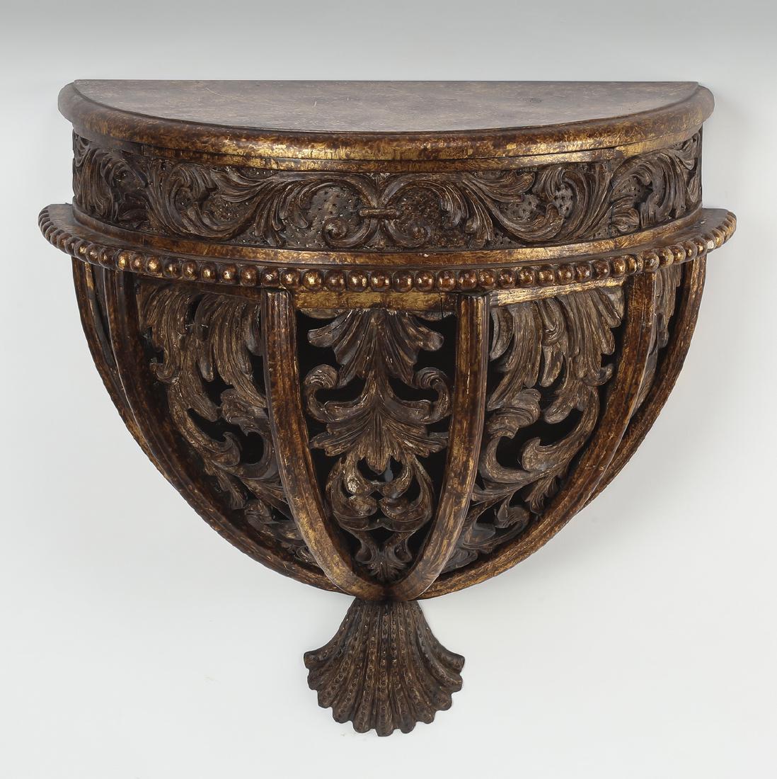 Maitland Smith style Baroque wall bracket, 20"h: Maitland Smith style Baroque wall bracket, executed in giltwood, having a demi-lune top with gold highlights, surmounting a tapering pierced foliate cage terminating to a shell pendant, 20"h x 20.75"w
