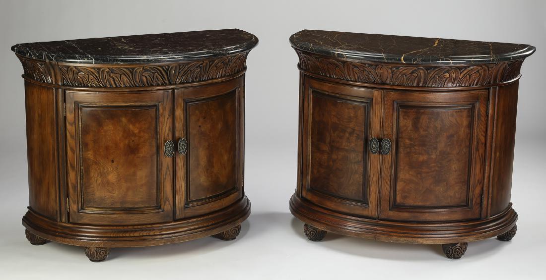 (2) Henredon mahogany and marble demilune commodes: Pair of Henredon mahogany and marble demilune commodes, each having a demilune marble surface resting on a conforming commode, with two doors opening to two shelves, the whole resting on four carved b